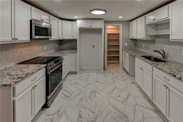 kitchen featuring light stone countertops, electric stove, decorative backsplash, white cabinetry, and sink