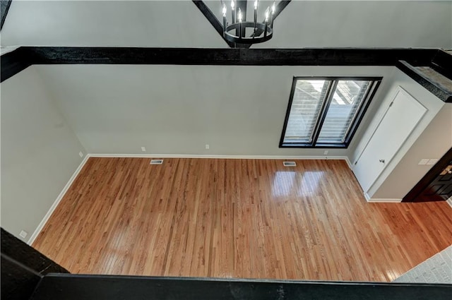 unfurnished dining area featuring a notable chandelier and light hardwood / wood-style floors