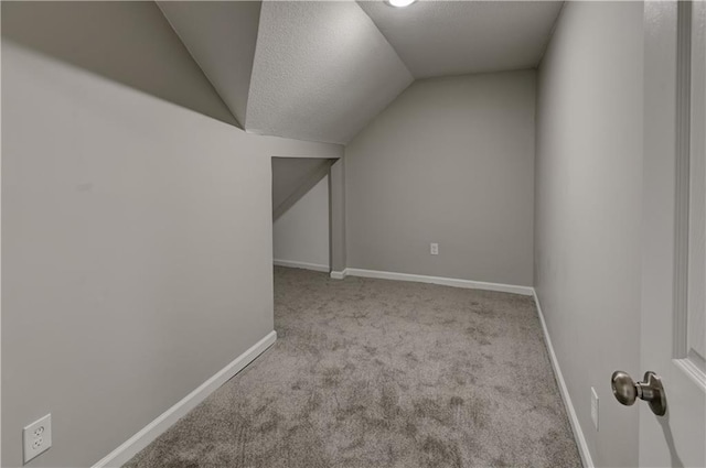 bonus room featuring light colored carpet, vaulted ceiling, and a textured ceiling