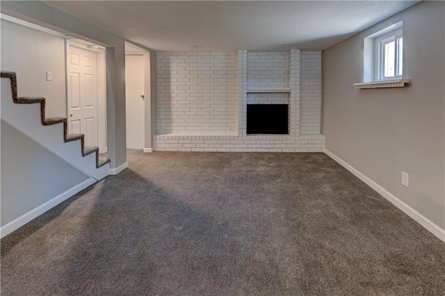 unfurnished living room featuring a brick fireplace and dark colored carpet