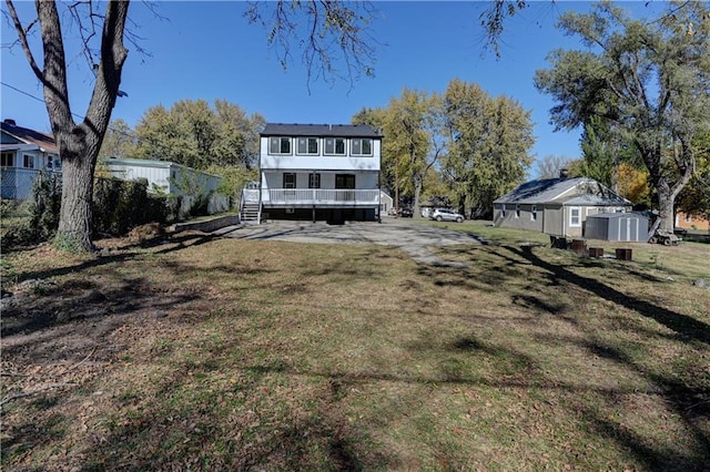 back of property with a lawn and a storage shed