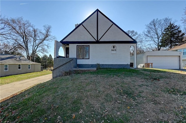 view of front of house with an outbuilding, a front yard, and a garage