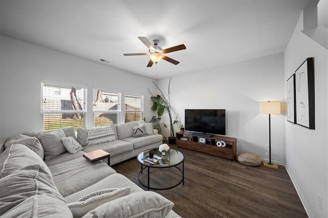 living room featuring dark wood-type flooring and ceiling fan