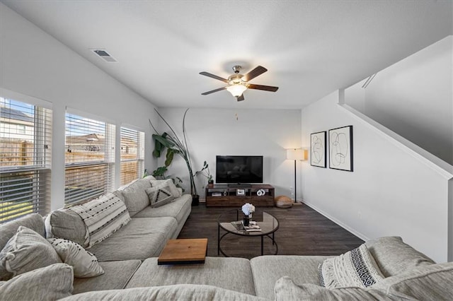 living room featuring dark wood-type flooring and ceiling fan