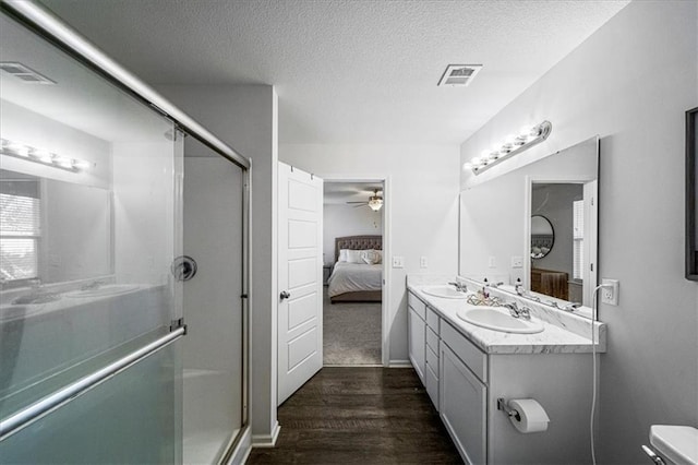 bathroom featuring hardwood / wood-style floors, ceiling fan, a textured ceiling, vanity, and an enclosed shower