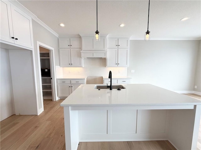 kitchen with white cabinetry, sink, and pendant lighting