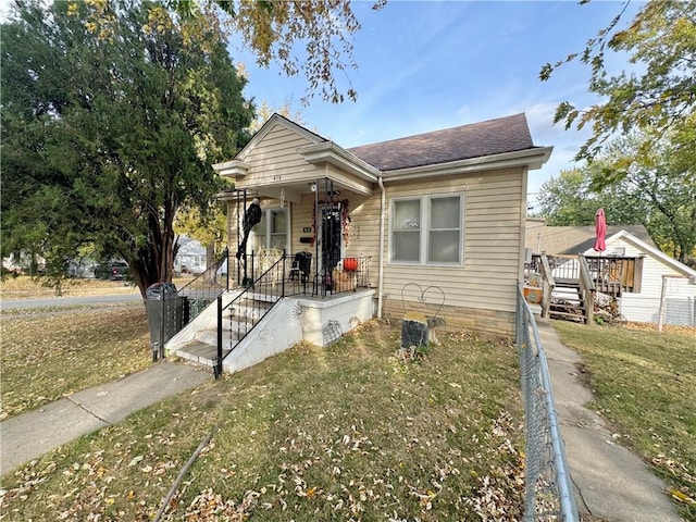 bungalow-style house with covered porch and a front lawn