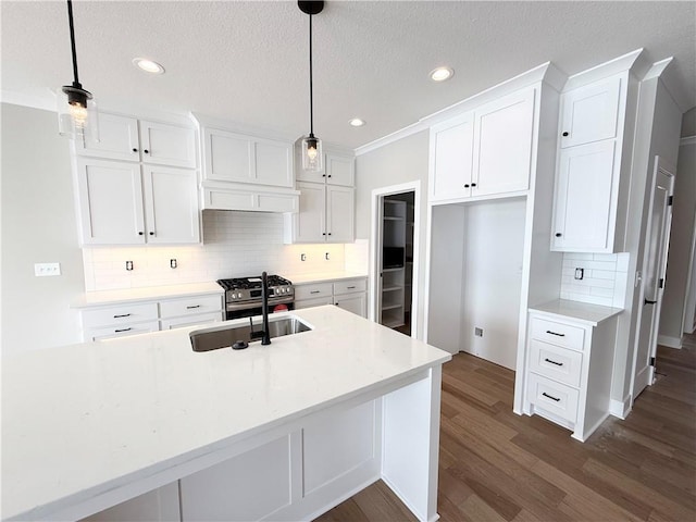 kitchen featuring pendant lighting, dark wood-type flooring, sink, and white cabinets