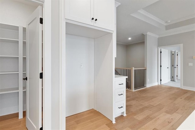 interior space featuring recessed lighting, light wood finished floors, ornamental molding, and an upstairs landing