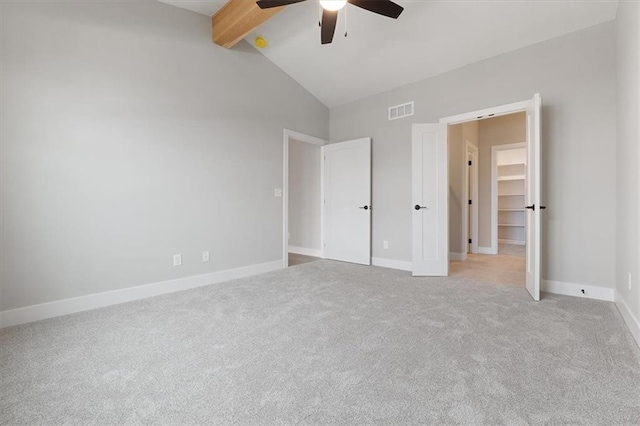 unfurnished bedroom with baseboards, vaulted ceiling with beams, visible vents, and light colored carpet
