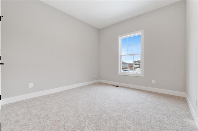 unfurnished room featuring baseboards, visible vents, and light colored carpet