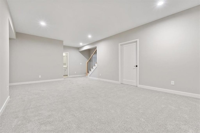 finished basement featuring recessed lighting, baseboards, stairs, and light colored carpet