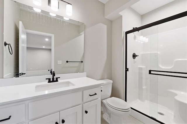 bathroom featuring a shower stall, toilet, and vanity