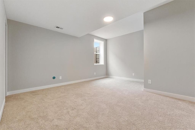 spare room featuring baseboards, visible vents, and carpet