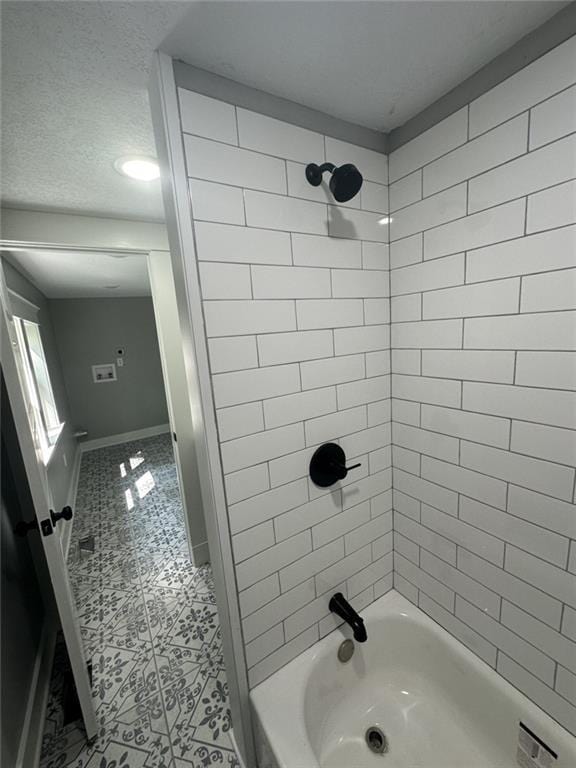 bathroom featuring tile patterned flooring, shower / washtub combination, a textured ceiling, and baseboards