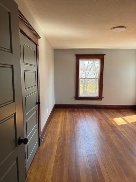 empty room featuring hardwood / wood-style floors and baseboards