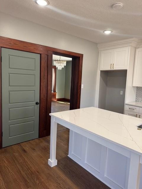 kitchen with dark wood-style floors, white cabinets, recessed lighting, and light stone countertops