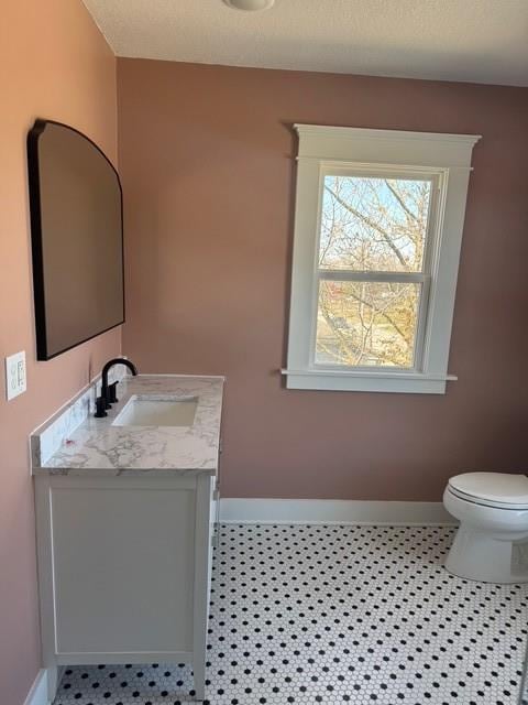 bathroom with tile patterned floors, baseboards, toilet, and vanity