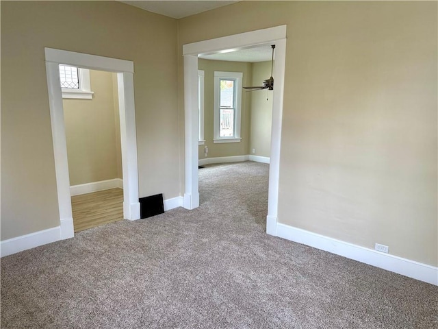 carpeted empty room featuring ceiling fan