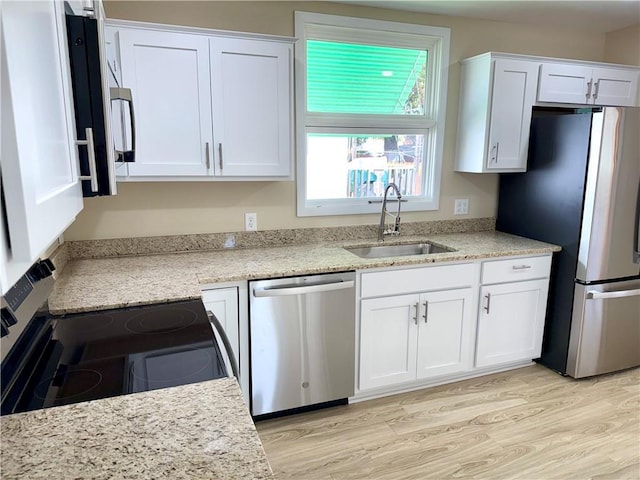 kitchen featuring white cabinets, sink, light wood-type flooring, and stainless steel appliances