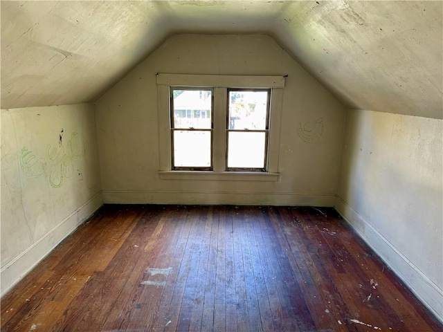 bonus room with vaulted ceiling and dark wood-type flooring