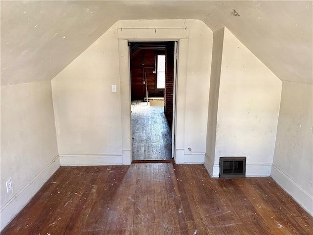 additional living space with hardwood / wood-style flooring and vaulted ceiling