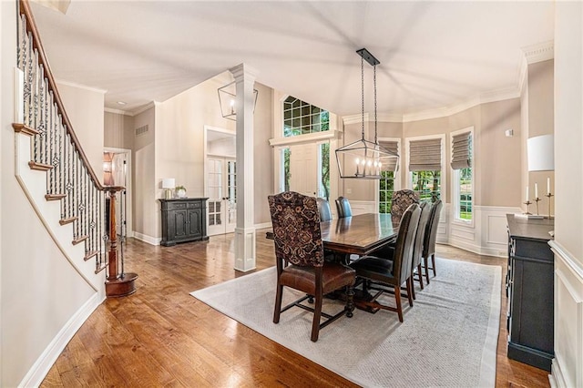 dining area with crown molding, a notable chandelier, and hardwood / wood-style flooring