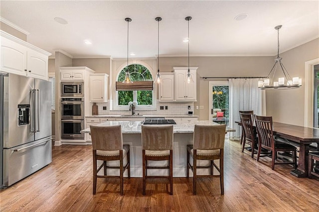 kitchen featuring a center island, appliances with stainless steel finishes, light stone counters, and white cabinetry