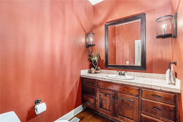 bathroom featuring vanity, toilet, and hardwood / wood-style flooring