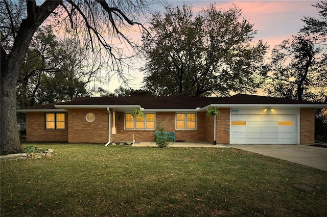 single story home with a garage and a yard