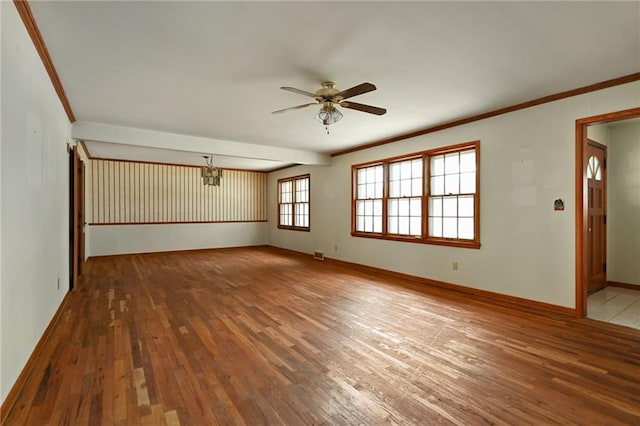 spare room with wood-type flooring, ceiling fan with notable chandelier, and crown molding