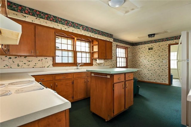 kitchen with exhaust hood, a healthy amount of sunlight, a kitchen island, and dark carpet