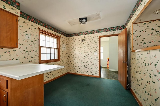 interior space with dark colored carpet and kitchen peninsula