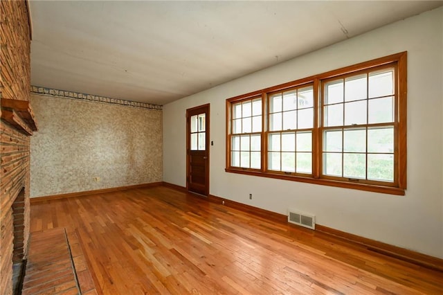 interior space with a brick fireplace and light wood-type flooring