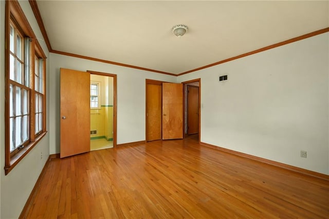 unfurnished room with ornamental molding and light wood-type flooring