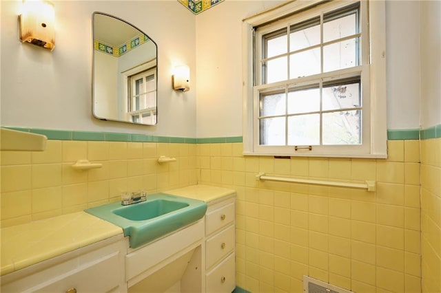 bathroom with vanity and tile walls