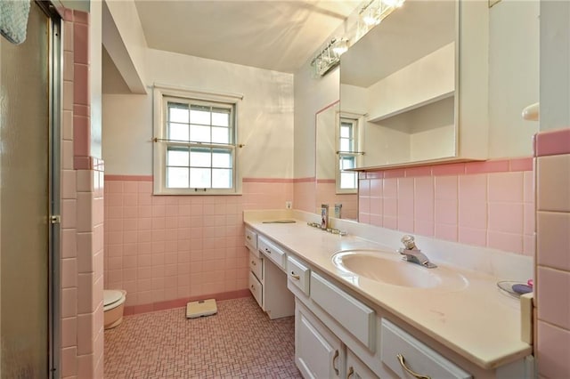 bathroom featuring vanity, an enclosed shower, tile patterned floors, toilet, and tile walls