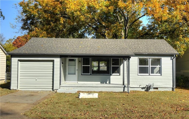 820 W Oak St, Chanute, KS 66720 - ranch-style house featuring a garage, a front lawn, a shingled roof, covered porch, and concrete driveway