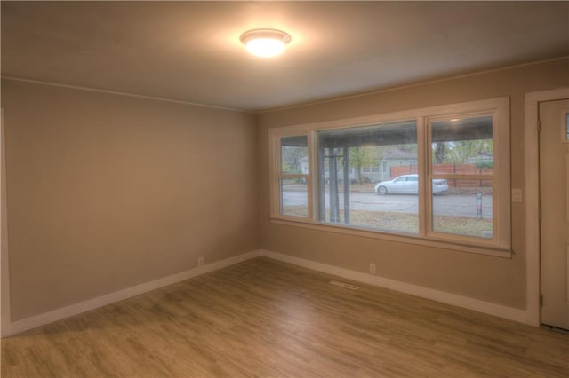 unfurnished room featuring wood-type flooring and ornamental molding