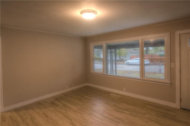 820 W Oak St, Chanute, KS 66720 - empty room with healthy amount of natural light, light wood finished floors, and baseboards