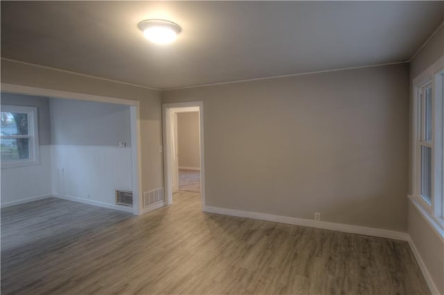 spare room with hardwood / wood-style flooring and crown molding