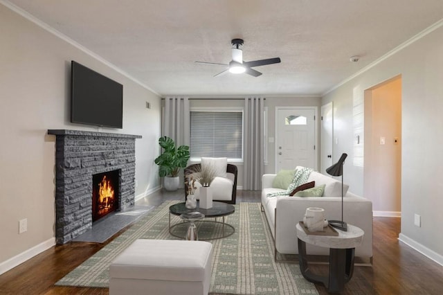 living room with ornamental molding, ceiling fan, a fireplace, and dark hardwood / wood-style flooring