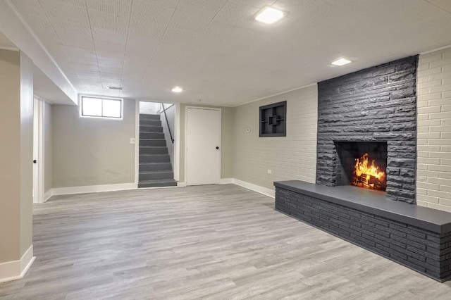 basement featuring a fireplace and light hardwood / wood-style floors