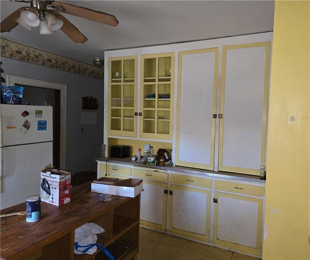 kitchen with ceiling fan, white refrigerator, and light tile patterned floors