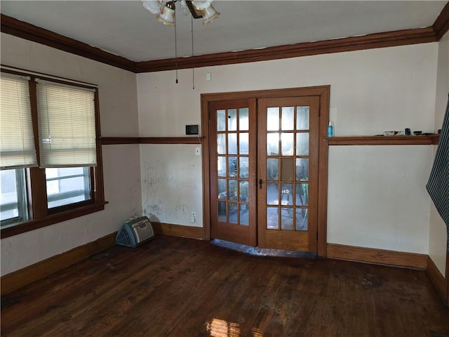 empty room with dark hardwood / wood-style flooring, ornamental molding, and french doors