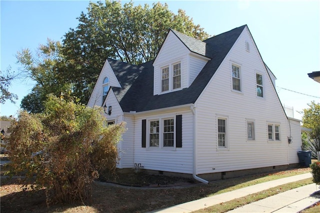 1201 W 4th St, Coffeyville, KS 67337 - view of side of property with a shingled roof and crawl space