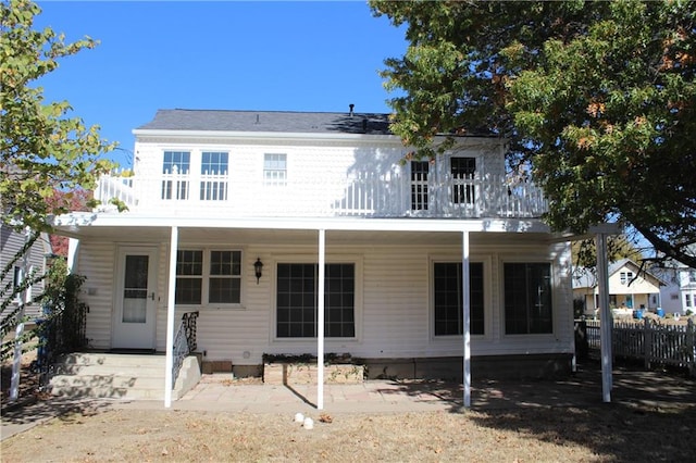 rear view of property featuring covered porch and a patio area