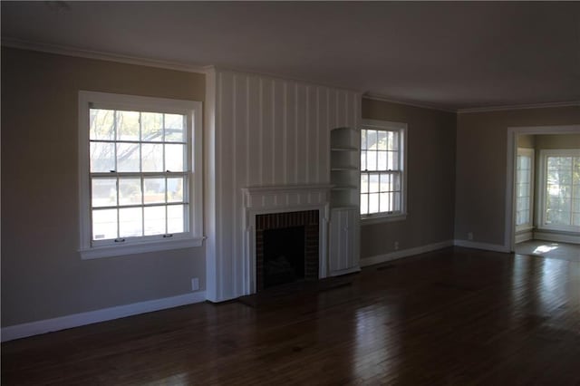 unfurnished living room with ornamental molding, dark wood-type flooring, and a brick fireplace