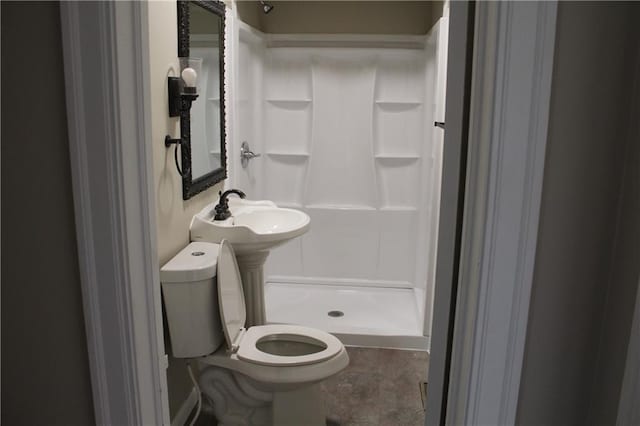 bathroom with toilet, walk in shower, and sink