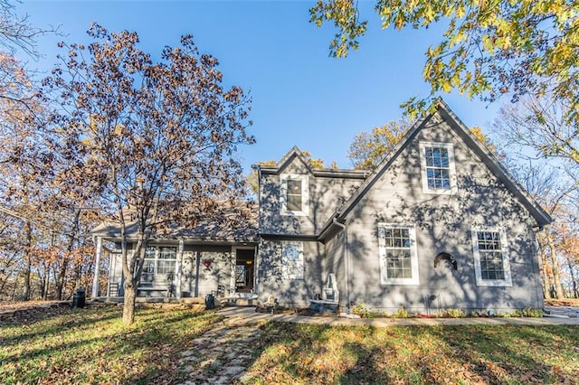 tudor-style house featuring a front lawn